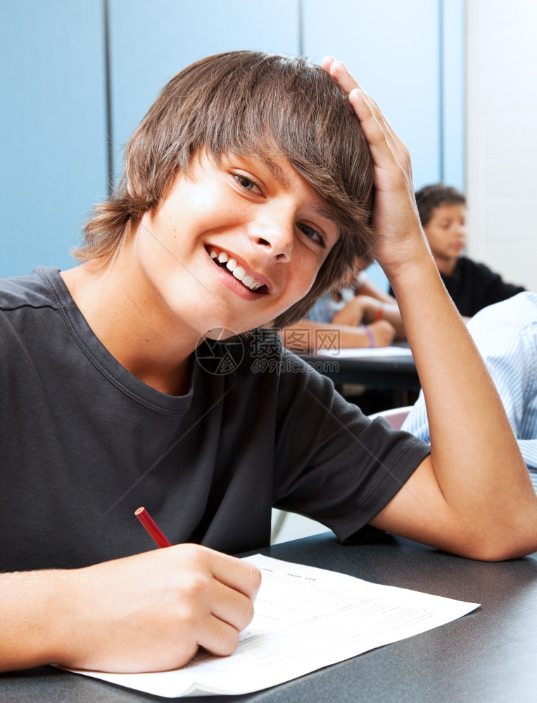 友善的微笑青少年男孩在学校教室里图片