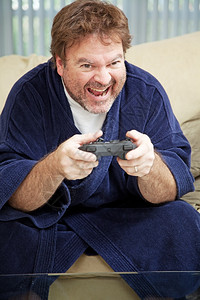 在家穿浴袍的失业男子整天玩电游戏图片