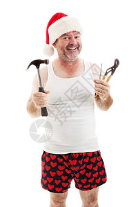 父亲带着圣诞老人的帽子微笑着拿工具他准备送圣诞礼物图片