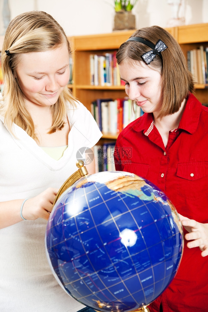 在校女生利用一个地球在图书馆进行研究图片