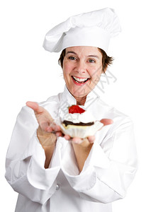 漂亮的女糕点厨师拿着美味的芝士蛋糕饼上面加了草莓和巧克力图片