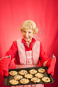 甜美的老外婆拿着她自制的饼干盘子有发短信的房间图片
