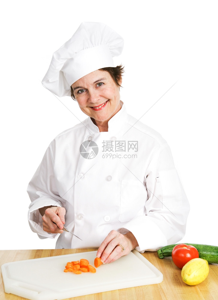 穿着制服的小女厨师在房的切板上开各种新鲜有机蔬菜在白色背景上孤立无援图片