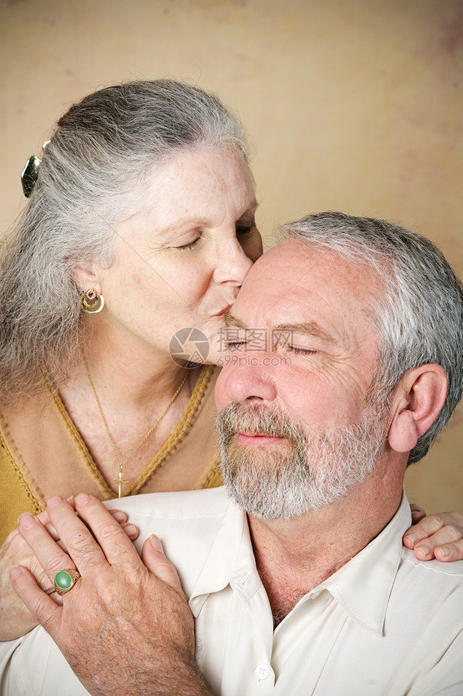 美丽的老妇人在前额上亲吻她丈夫图片