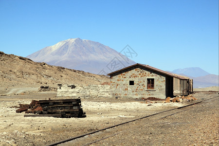 玻利维亚Uyuni附近石头沙漠和山丘的铁路图片