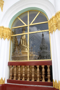 缅甸仰光瑞达贡帕亚窗户上的金色佛塔倒影图片