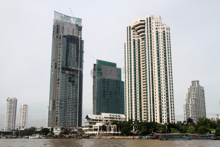 泰国曼谷ChaoPhraya河上的建筑物和渡轮船图片
