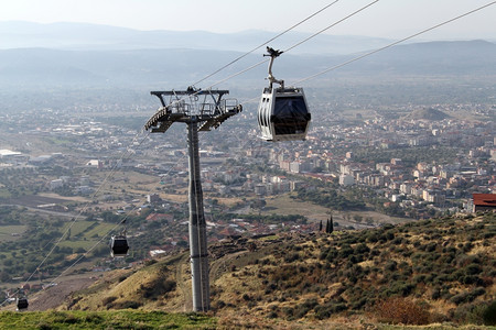 土耳其Bergama与大都会在Hjill的有线汽车在土耳其Bergama的hjill背景图片