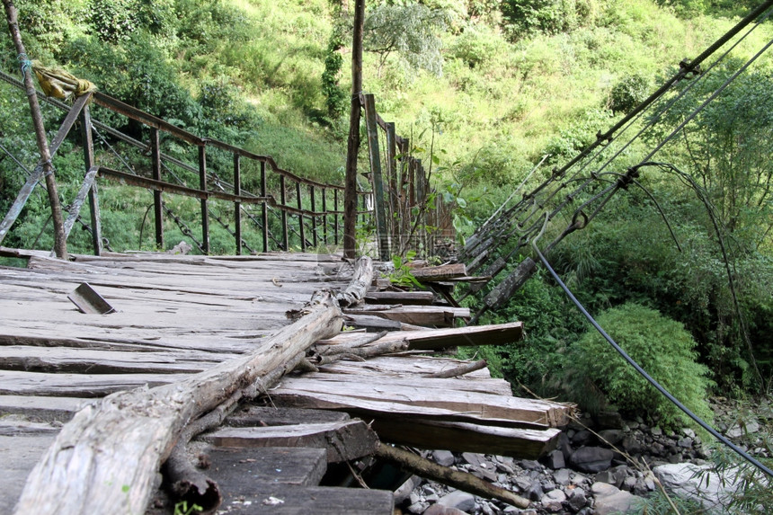 尼泊尔山上旧木悬吊桥图片
