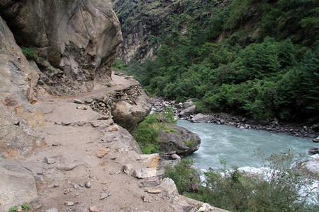尼泊尔的泥土路和河流附近山图片