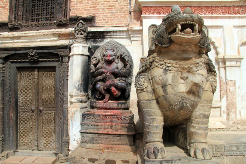 尼泊尔Bhaktapur艺术博物馆木门附近的雕像图片