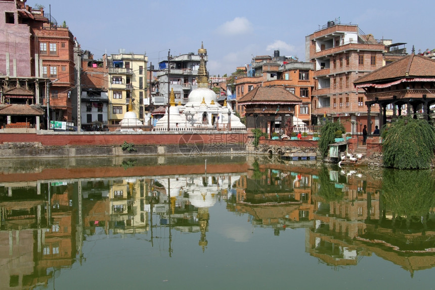 尼泊尔Patan池塘附近的建筑物和Stupa图片