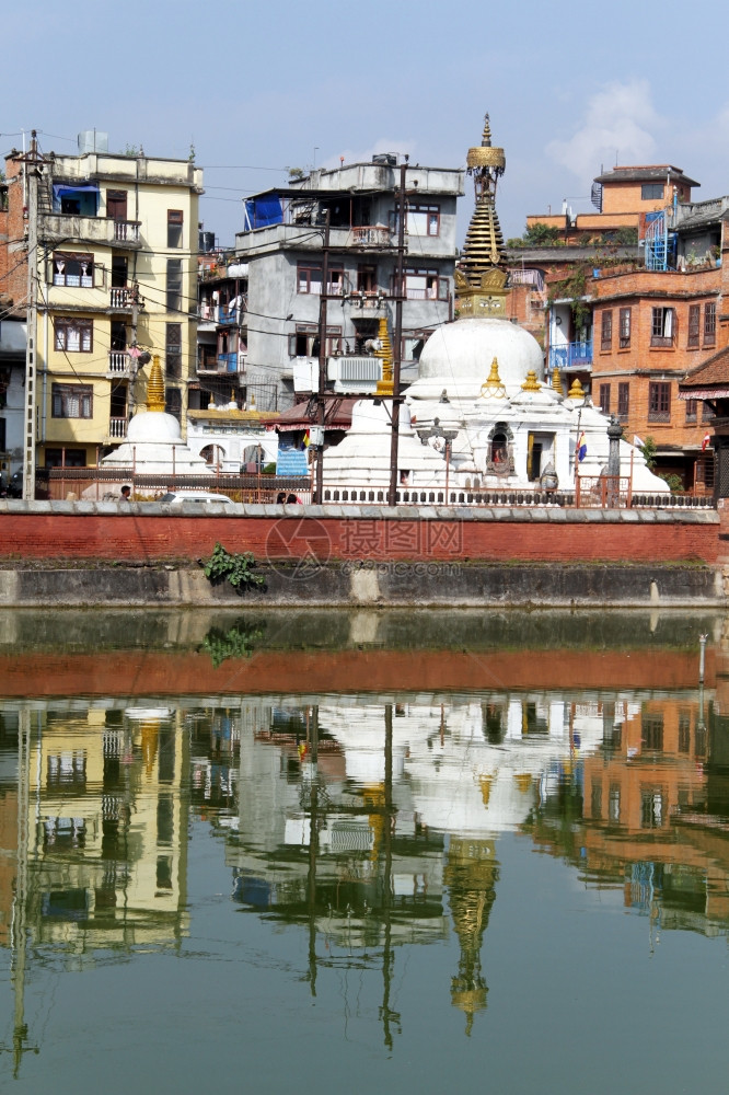 Stupa和尼泊尔Patan池塘附近的建筑图片
