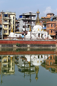 Stupa和尼泊尔Patan池塘附近的建筑图片