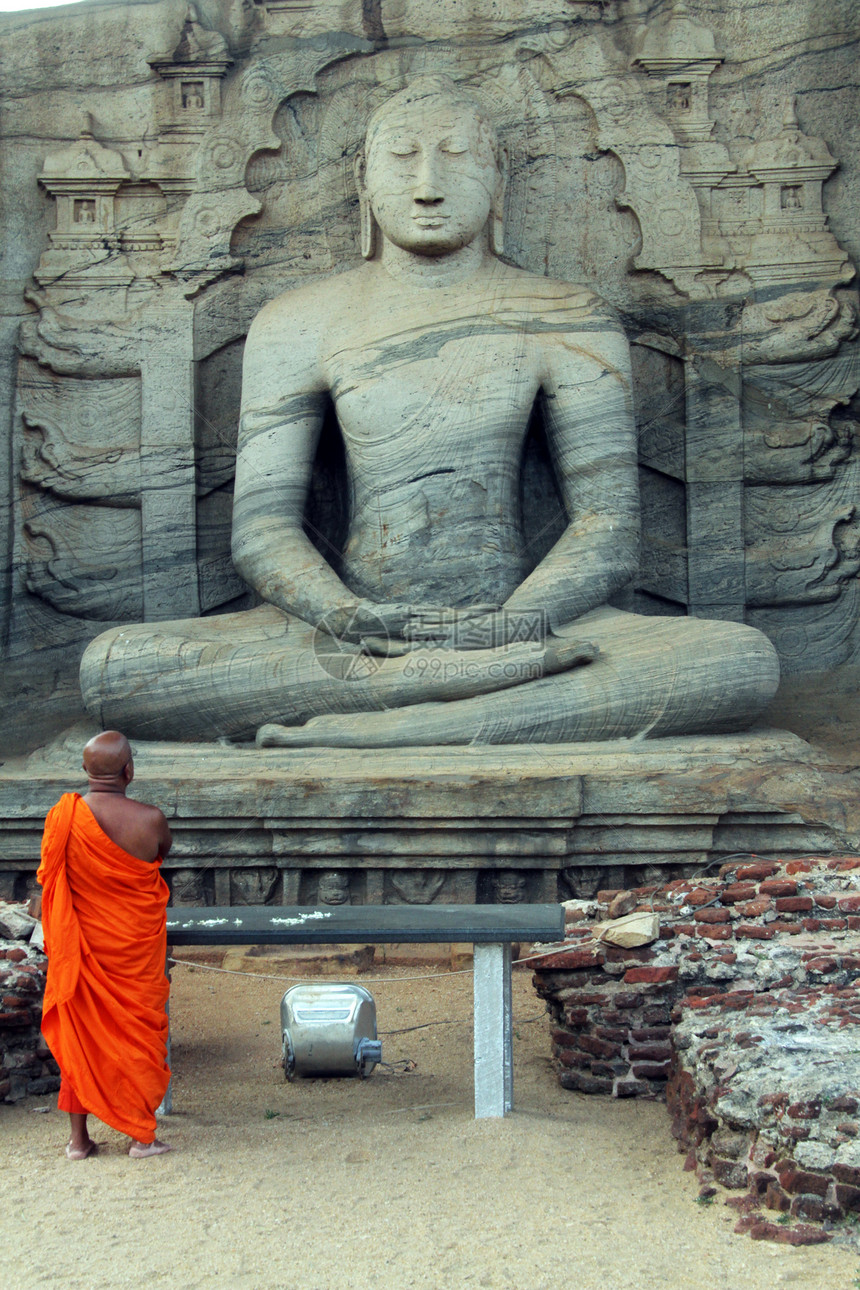 在斯里兰卡Polonnaruwa的佛像旁边祈祷图片