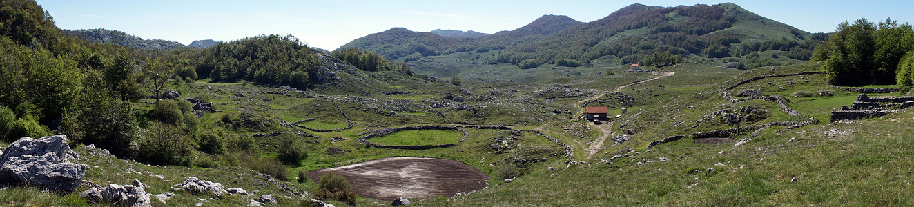 黑山有耕地和教堂的山谷全景图片