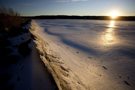 冬季冷冻萨斯喀彻温北部湖日落图片