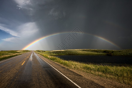 道路和风暴云后彩虹图片