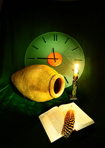 仍然活在时钟安法拉开放圣经和绿天鹅绒上的亮蜡烛之中图片