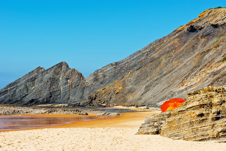 葡萄牙大西洋海滩上的橙色保护伞图片