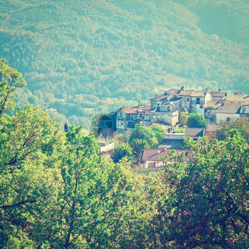 中世纪意大利城位于山顶上环绕着森林覆盖的山脉Instagram效应图片