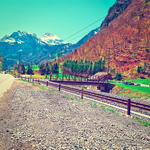 与瑞士雪峰阿尔卑斯山背景下的铁路平行高速公运Instagram效应背景图片
