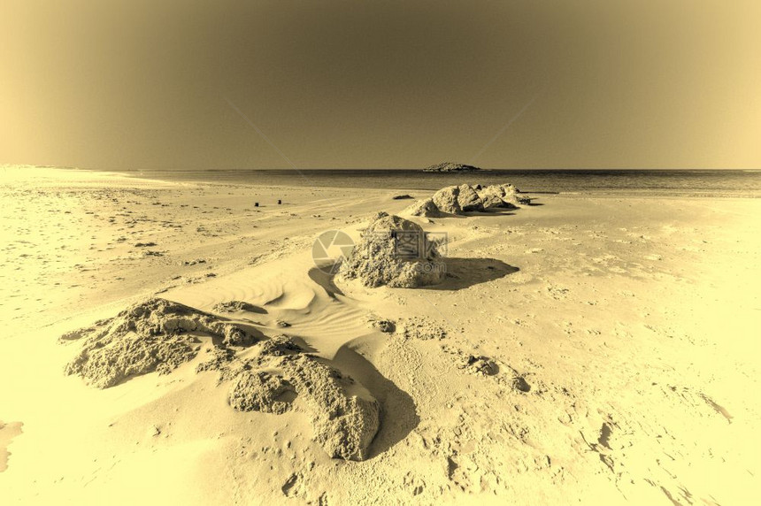 从以色列地中海岸看一个小岛的景象沙吹过海滩丘风吹在以色列的沙丘上图片