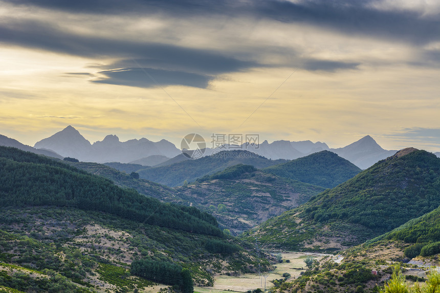 在西班牙美丽的景色中坎塔布里亚山脉的景色日出时沿干河床运行的电线图片