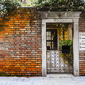 威尼斯旧房子的开放工门进入中世纪意大利城市的住宅图片