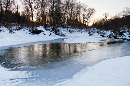 冬季日落时森林溪流的河岸图片