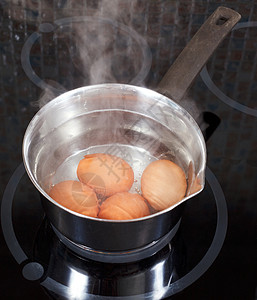 一锅水厨房电炉的金属锅中煮鸡蛋背景