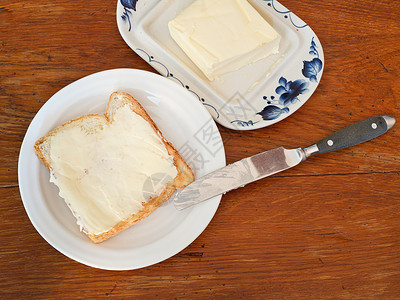 白板上的面包和黄油三明治刀奶油木板上的黄图片
