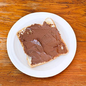 甜三明治从新鲜吐司巧克力撒在白板上图片