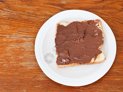 甜三明治从新鲜吐司上方的甜三明治和巧克力木桌上的餐刀图片
