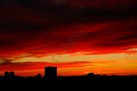 城市房屋上空的阴暗红色日出天空图片