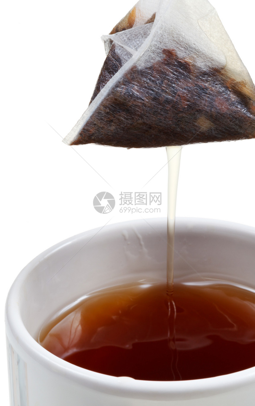 从杯中取茶袋与泡关闭孤立在白色背景上图片