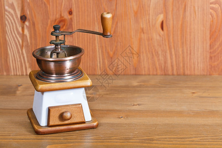木制桌上的老旧手工制咖啡机图片