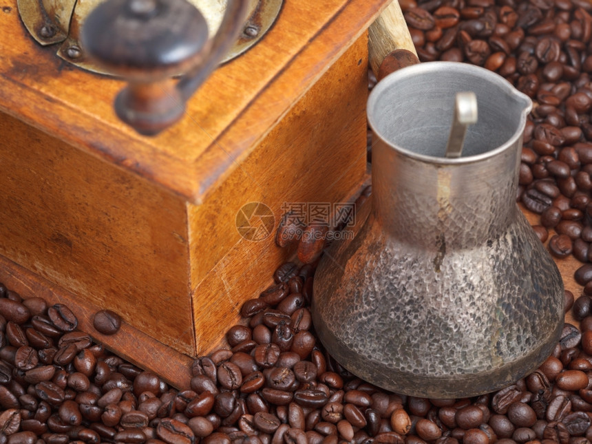 在许多烤咖啡豆上加二手咖啡机和铜锅图片