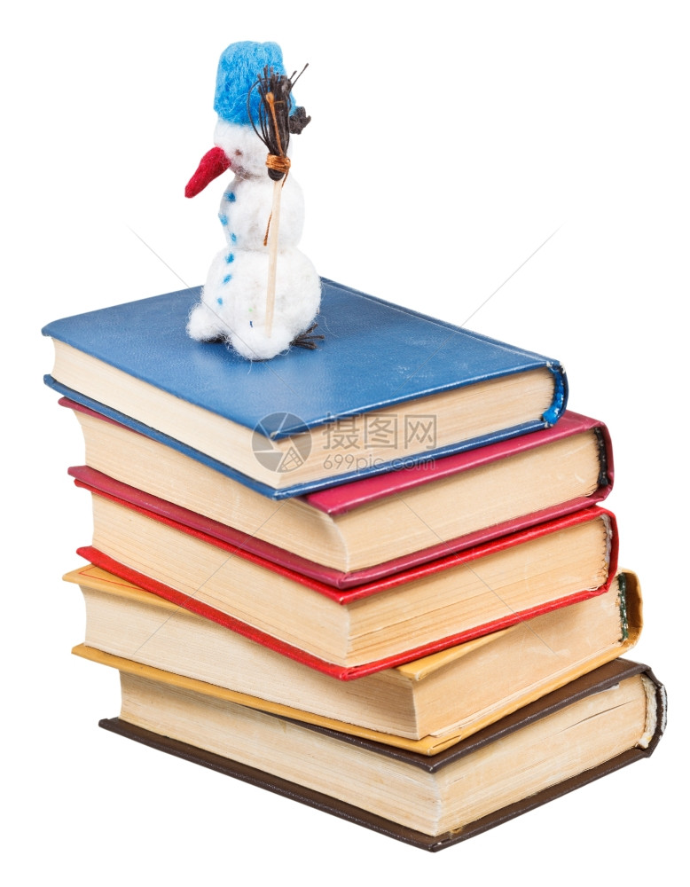 感觉柔软的玩具雪人站在旧书上孤立白色背景图片