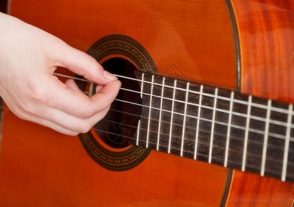 在音响吉他上女用手臂弹奏声乐吉他图片