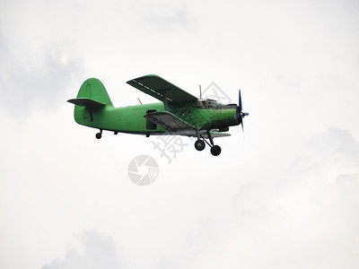在蓝天飞行的绿色飞机图片