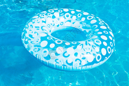 夏季日蓝色露天游泳池中的可充气游泳圈图片