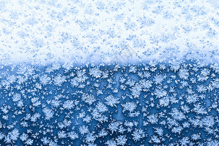 寒冷的冬城市蓝色夜晚窗边有雪花和冻霜图片