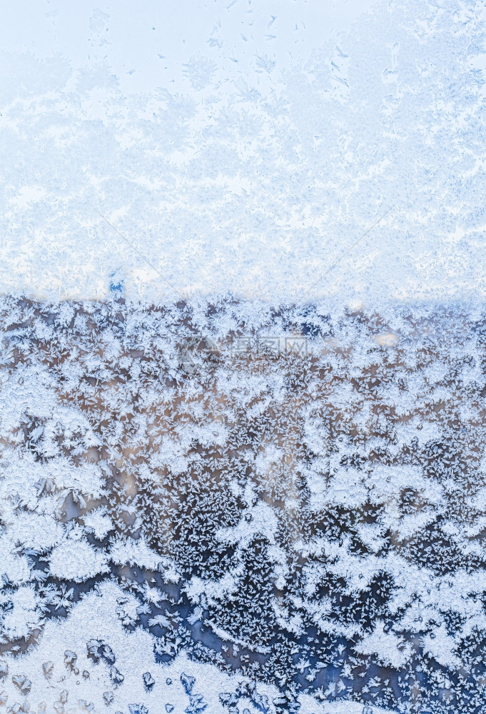 寒冷的冬天透过雪覆盖的窗口可以看到城市的景色图片