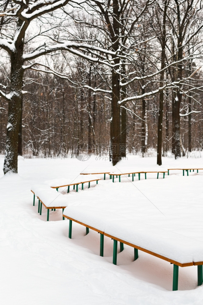 冬季城市公园上白雪覆盖的长椅图片