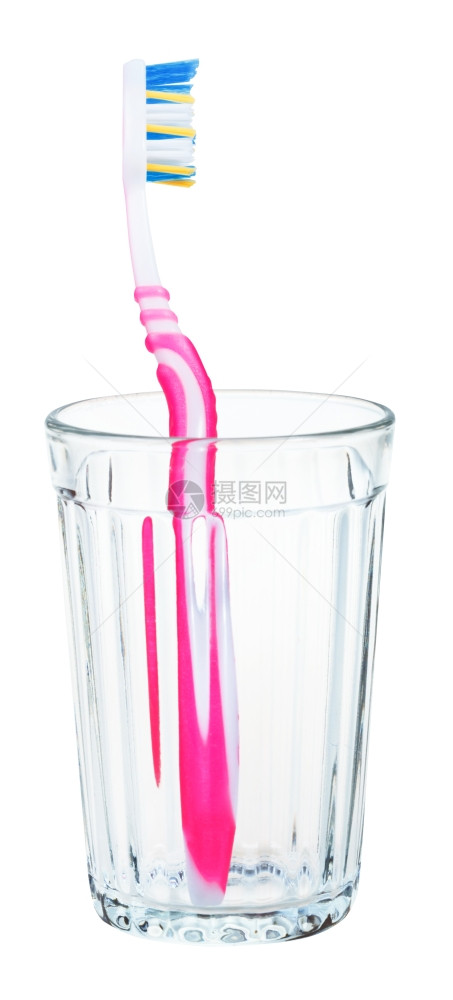 玻璃中的粉红色牙刷白背景上隔绝的玻璃粉红色牙刷图片