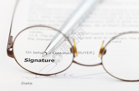透过眼镜的销售合同和银笔签字背景图片