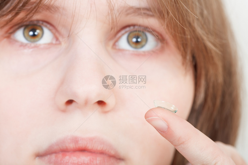 女孩用隐形眼镜指着你的手贴近眼睛图片