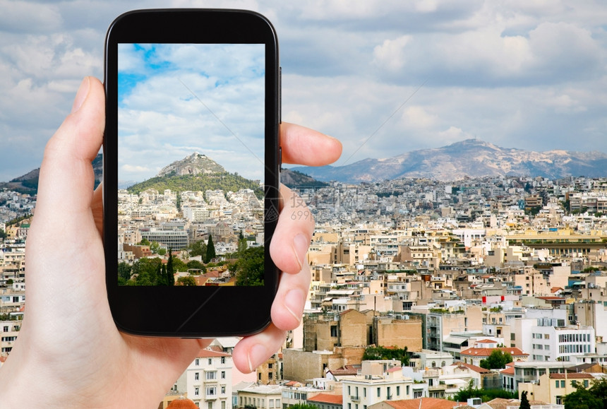 旅行概念希腊雅典市在移动工具上拍摄雅典市天际照片的游客图片