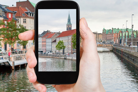 旅行概念在丹麦移动工具上拍摄哥本哈根市景照片的游客高清图片